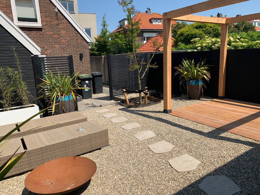 Moderne tuin met pergola, vlonder en stijlvolle afscheiding in Noordwijk